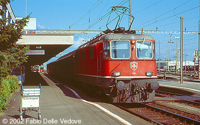 Zum Vergr&ouml;&szlig;ern klicken - Die rote Re 4/4II 11144 mit nur einem Stromabnehmer vor dem Ersatzzug f&uuml;r EC 164 "Kaiserin Elisabeth" nach Z&uuml;rich HB (Buchs SG, September 2002).