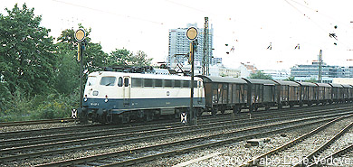 Die B&uuml;gelfalten-110 437-1 kommt mit einem G&uuml;terzug vom Rangierbahnhof M&uuml;nchen-Laim (M&uuml;nchen Heimeranplatz, August 1990)