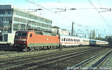 Die verkehrsrote 120 114-4 schiebt den IR 2097 (M&uuml;nchen Hbf 15:37 - Salzburg Hbf 17:23) durch den Bahnhof Heimeranplatz (M&uuml;nchen, Fr&uuml;hling 2002).