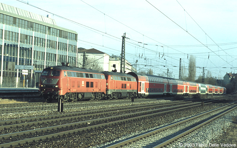 218 440-6 in orientrot und 218 442-2 in verkehrsrot donnern mit ihren acht Doppelstockwagen als RE 31430 (M&uuml;hldorf (Obb.) 15:37 - M&uuml;nchen Hbf 17:32) durch den Heimeranplatz (M&uuml;nchen, Fr&uuml;hling 2002).