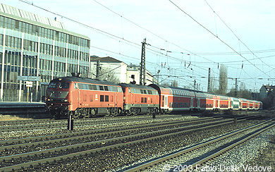 218 440-6 in orientrot und 218 442-2 in verkehrsrot donnern mit ihren acht Doppelstockwagen als RE 31430 (M&uuml;hldorf (Obb.) 15:37 - M&uuml;nchen Hbf 17:32) durch den Heimeranplatz (M&uuml;nchen, Fr&uuml;hling 2002).
