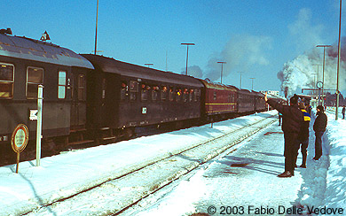 Zum Vergr&ouml;&szlig;ern klicken - Die Fahrg&auml;ste schauen aus ge&ouml;ffneten Fenstern, die Eisenbahnfreunde auf dem Bahnsteig fotografieren und winken (Kempten, 15.02.2003).